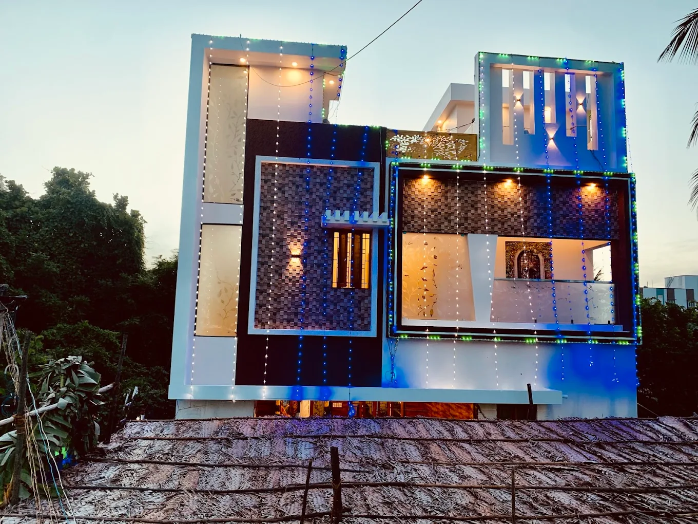 Contemporary home facade lit with decorative lighting at dusk