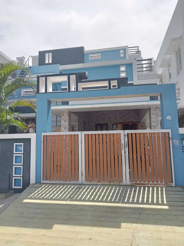 Blue elevation home with wooden sliding gate
