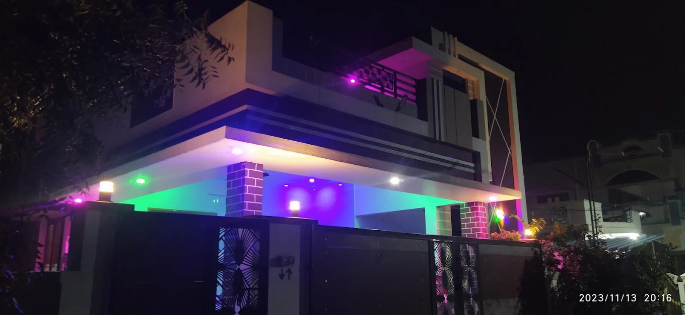 Modern house exterior illuminated with coloured facade lighting at night